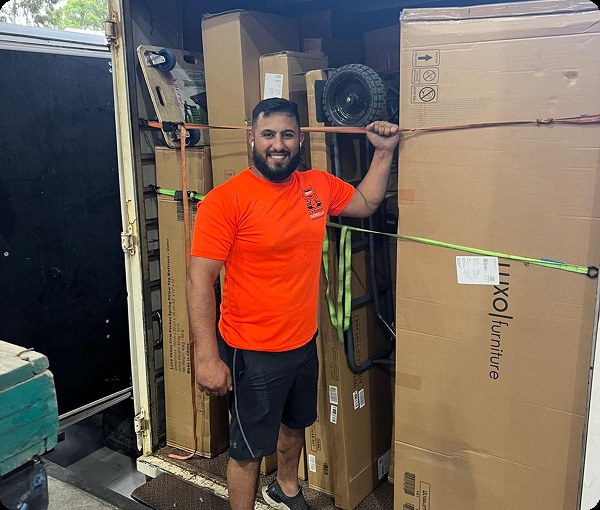 Mover preparing boxed furniture inside a truck